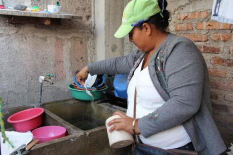 Erika Diaz abatizando vivienda en barrio Sandino Norte de Matagalpa.